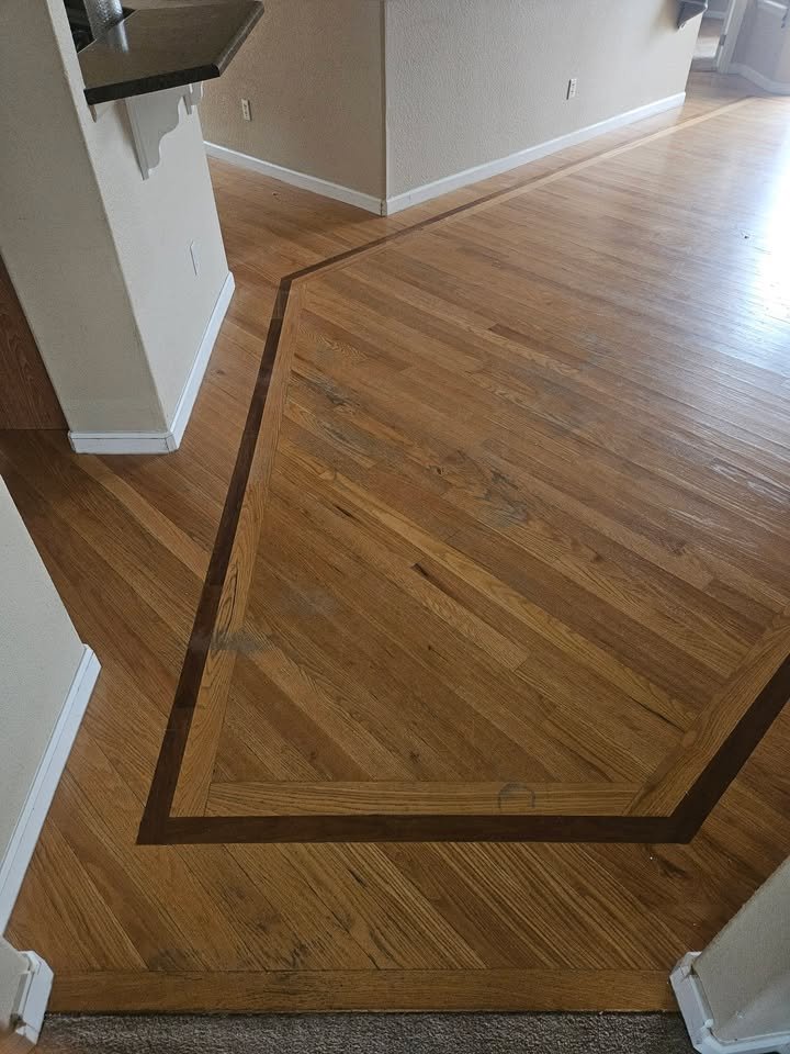 Refinished hardwood floor with custom dark border inlay after full sand and finish by All Floors Pueblo